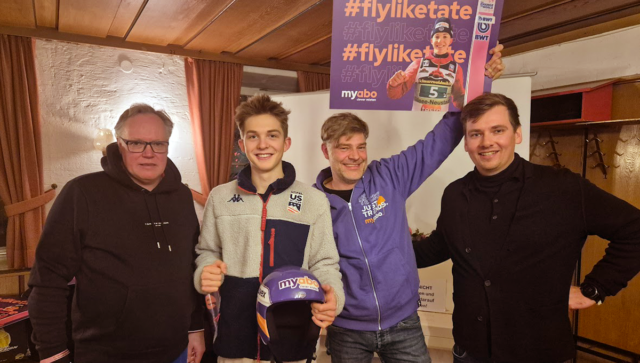 Benno Bartels vom myabo-Team übergibt Tate Frantz den gebrandeten myabo-Helm bei einer feierlichen Zeremonie in Oberstdorf, begleitet von einer Autogrammstunde.